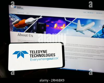 Persona che possiede uno smartphone con il logo della società statunitense Teledyne Technologies incorporato sullo schermo davanti al sito Web. Concentrarsi sul display del telefono. Foto Stock