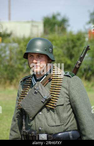 Rievocazione, rievocazione del soldato dell'esercito tedesco della seconda guerra mondiale. Fanteria dell'esercito tedesco (Wehrmacht). Uniforme con cintura per munizioni, astuccio, fucile Foto Stock