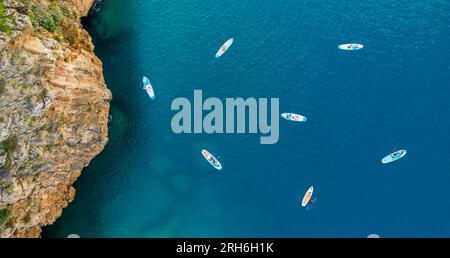 Vista aerea delle persone che fanno paddle in piedi in una baia tranquilla Foto Stock