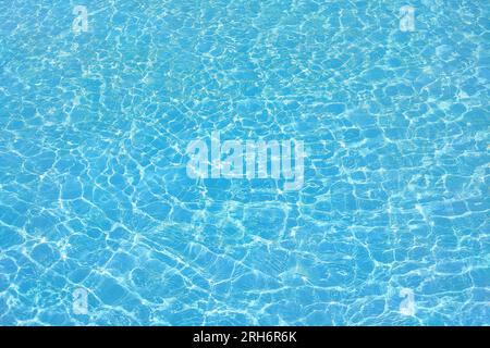Superficie limpida di colore blu e acqua calma con ondulazione. Sfondo blu brillante. Acqua in piscina. Foto Stock
