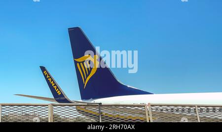 Luqa, Malta - 7 agosto 2023: Pinna di coda e aletta di un Boeing 737 operato dalla compagnia aerea irlandese Ryanair isolata contro un cielo blu. Foto Stock