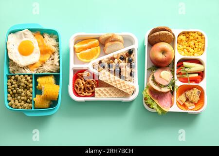 Cestini per il pranzo con diversi piatti deliziosi su sfondo turchese Foto Stock