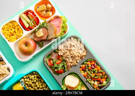 Cestini per il pranzo con diversi piatti deliziosi su sfondo colorato Foto Stock