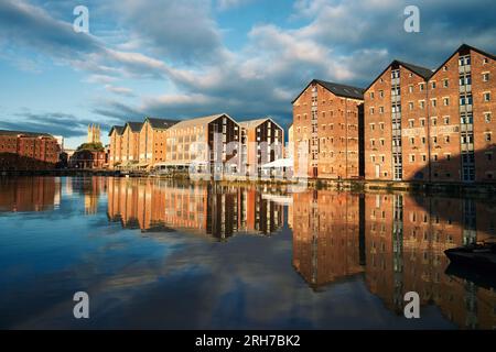 I magazzini dei moli di Gloucester si riflettono nel canale. Cattedrale di Gloucester sullo sfondo. Centro storico di Gloucester in Inghilterra. Foto Stock