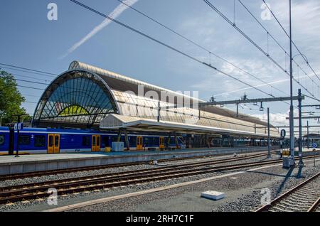 Zwolle, Paesi Bassi, 9 agosto 2023: Vista attraverso i binari della stazione ferroviaria centrale verso il tetto a forma di cupola originale della stazione Foto Stock