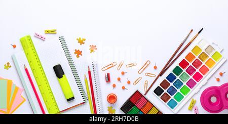 Ritorno a scuola. Plasticina per artigianato, matite, quaderni, righello e pitture aquarelle. Cancelleria colorata sul tavolo, distesa piatta. Istruzione co Foto Stock