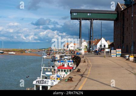 La banchina, in estate, nella città turistica del Norfolk settentrionale di Wells-Next-the-Sea con le sue barche da pesca ormeggiate lungo la bassa marea. Norfolk, Inghilterra Foto Stock