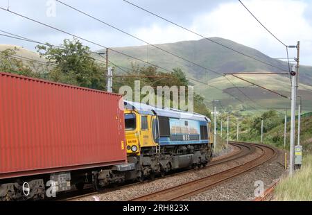 Classe 66 capannone diesel-elettrico loco, numero 66709 chiamato Sorrento, su un convoglio lungo la West Coast Main Line a Lowgill in Cumbria, l'11 agosto 2023. Foto Stock