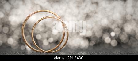 Gli anelli sono uno accanto all'altro. Fedi nuziali d'oro per il matrimonio degli sposi su sfondo chiaro con bokeh giallo lucido. Rendering 3D. Foto Stock