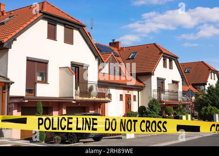 Nastro giallo della scena del crimine che blocca la strada Foto Stock