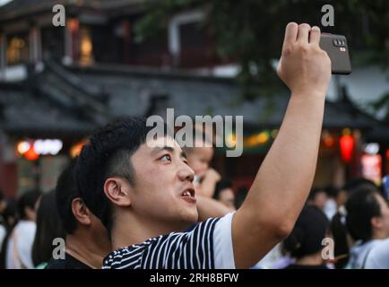 NANCHINO, CINA - 14 AGOSTO 2023 - i turisti fanno selfie presso il luogo panoramico del Tempio di Confuciusi lungo il fiume Qinhuai a Nanchino, Jiangsu della Cina orientale Foto Stock