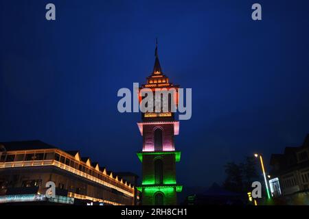 Srinagar, India. 14 agosto 2023. La gente cammina davanti alla torre dell'orologio illuminata con la bandiera nazionale dell'India alla vigilia del giorno dell'indipendenza del paese a Srinagar il 14 agosto 2023. (Foto di Mubashir Hassan/Pacific Press) credito: Pacific Press Media Production Corp./Alamy Live News Foto Stock