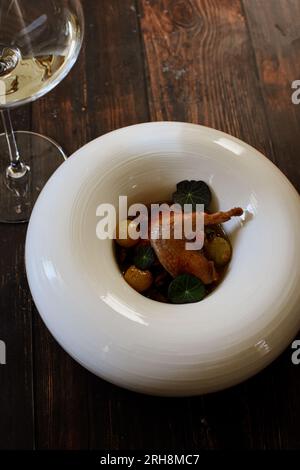 Quail con uva (Cailles aux uva passa) servita con vino bianco. Foto Stock