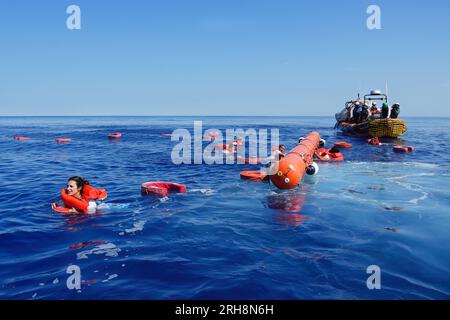 Mar Mediterraneo, Italia. 14 agosto 2023. I membri del team Doctors Without Borders saltano in acqua per essere salvati dai colleghi durante un esercizio di simulazione prima di entrare nella zona SAR. 36a rotazione di Medici senza frontiere a bordo dei Geo Barents. Credito: SOPA Images Limited/Alamy Live News Foto Stock