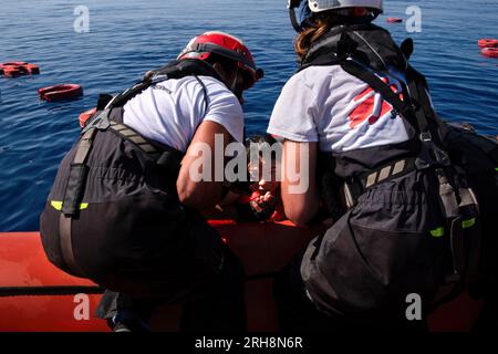 Mar Mediterraneo, Italia. 14 agosto 2023. Due membri della squadra di soccorso di Medici senza frontiere portano uno dei loro colleghi nel Rhib durante un'esercitazione. 36a rotazione di Medici senza frontiere a bordo dei Geo Barents. Credito: SOPA Images Limited/Alamy Live News Foto Stock