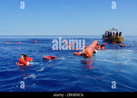 Mar Mediterraneo, Italia. 14 agosto 2023. I membri del team Doctors Without Borders saltano in acqua per essere salvati dai colleghi durante un esercizio di simulazione prima di entrare nella zona SAR. 36a rotazione di Medici senza frontiere a bordo dei Geo Barents. (Foto di Ximena Borrazas/SOPA Images/Sipa USA) credito: SIPA USA/Alamy Live News Foto Stock