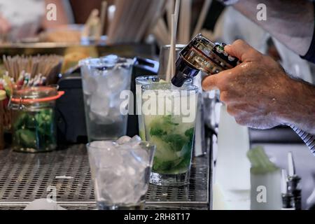 Il barista prepara un cocktail mojito con lime e menta fresca in un ristorante bar di Huntington Beach, Orange County, California, USA Foto Stock