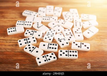 Piastrelle Domino su tavolo in legno. Domino è uno dei giochi classici più famosi. Foto Stock