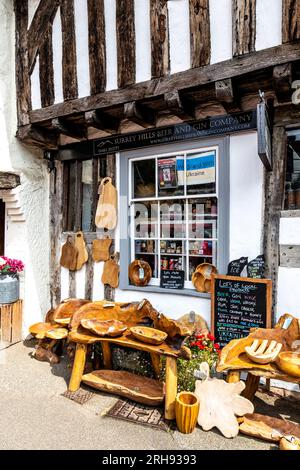 Decorazioni artigianali in legno rustico all'esterno del negozio di birra e gin di Surrey Hills, Shere Village, Surrey, Inghilterra Foto Stock