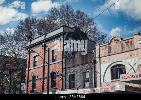 Un edificio lungo Surry Hills, Sydney con graffiti all'ultimo piano. Foto Stock