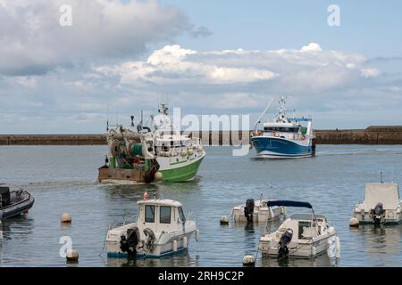 Port-en-Bessin-Huppain, Francia - 07 24 2023: Due pescherecci che entrano nel porto si incrociano Foto Stock