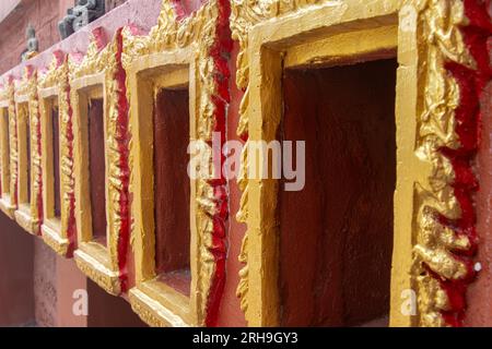 Nicchie decorative nella parete di un tempio buddista destinate a contenitori contenenti le ceneri del defunto, Thailandia Foto Stock