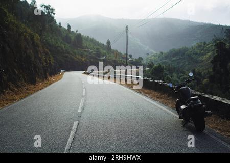 La motocicletta è parcheggiata sul lato dell'autostrada. Viaggi romantici in moto. Foto Stock