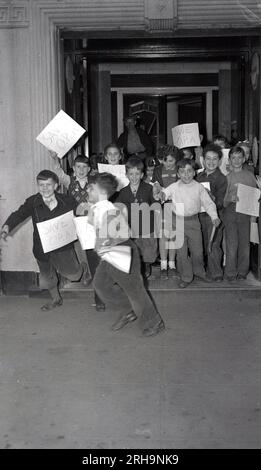 1946, storia, eccitati bambini corrono fuori da un ingresso di un condominio con cartelli scritti a mano che recano "Save O. P. A', New York, New York City, USA. Stavano cercando di firmare una petizione per aiutare a salvare l'Office of Price Administration (OPA) che era stato istituito nel 1941 per controllare il denaro (controlli dei prezzi per ridurre l'inflazione) e gli affitti all'inizio della seconda guerra mondiale. Foto Stock