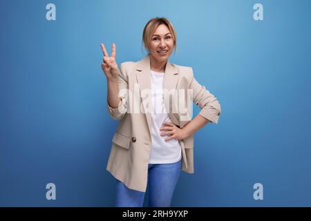 energica giovane donna d'affari bionda in giacca sullo sfondo dello studio Foto Stock