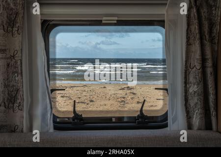 Spiaggia dell'oceano vista mare dalla finestra di un camper camper per camper. Viaggio in macchina sulla costa della svezia. Foto Stock