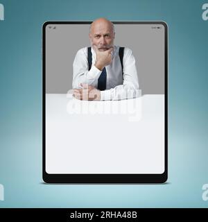 Uomo d'affari penoso in un tablet digitale, sta pensando con la mano sul mento, spazio vuoto per le copie, concetto di soluzione aziendale Foto Stock