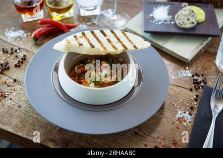 Gamberi PIL-PIL. Gamberoni, aglio, peperoncino e baguette. Delizioso primo piano del cibo tradizionale spagnolo servito per pranzo in una moderna cucina gourmet Foto Stock