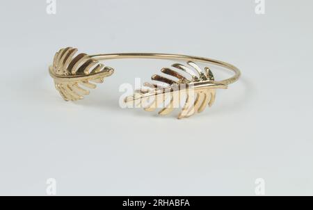 Lascia il bracciale in oro isolato su sfondo bianco. Foto Stock