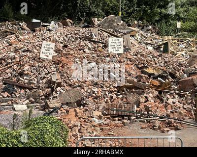 Il demolito pub Crooked House vicino a Dudley, West Midlands. I lavori hanno iniziato a delimitare i resti del pub, più di una settimana dopo che il suo guscio bruciato è stato demolito a seguito di un sospetto attacco doloso. I lavoratori del sito di Himley, dissero che l'area circostante era stata sigillata con scherma per motivi di sicurezza, a seguito delle proteste contro la distruzione del pub che vedevano segni e altri tributi posti tra le macerie. Data foto: Martedì 15 agosto 2023. Foto Stock