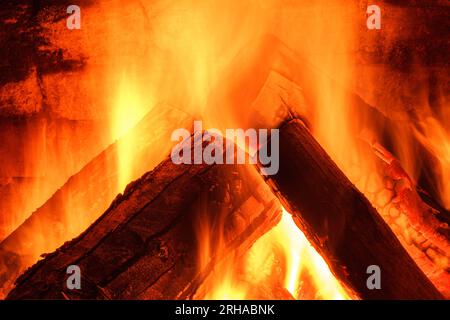 Caminetto a legna. Il fuoco si tiene caldo. Cresta di fiamma sul legno bruciato nel caminetto. Messa a fuoco morbida. Messa a fuoco sfocata Foto Stock