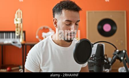 Giovane musicista arabo che canta canzoni nello studio di musica Foto Stock