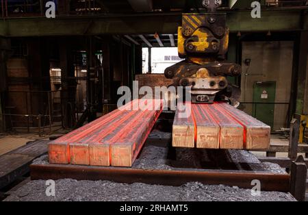 15 agosto 2023, bassa Sassonia, Georgsmarienhütte: I lingotti grezzi vengono caricati su un Teletrac (un treno semovente) per il trasporto al laminatoio della acciaieria Georgsmarienhütte GMH Group. Il fulcro della visita del ministro dell'ambiente della bassa Sassonia Meyer è il progetto "Georgsmarienhütte - Industry-driven Heat Revolution", che mira a sfruttare l'energia inutilizzata della acciaieria. Foto: Friso Gentsch/dpa Foto Stock