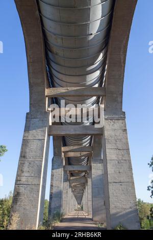 Strada di servizio che passa sotto l'Acedera Aqueduct. Canale di irrigazione Orellana, Las Vegas Altas del Guadiana, Estremadura, Spagna Foto Stock