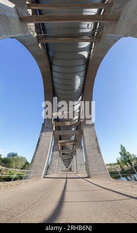 Strada di servizio che passa sotto l'Acedera Aqueduct. Canale di irrigazione Orellana, Las Vegas Altas del Guadiana, Estremadura, Spagna Foto Stock