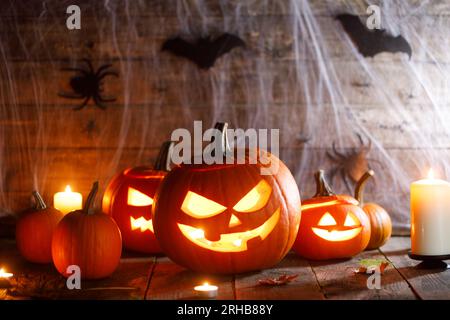 Halloween, decorazione e concetto di festa - zucche con pipistrelli, ragnatela e candele Foto Stock