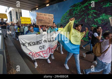 L'Aia, Paesi Bassi. 14 agosto 2023. Gli studenti marciano lungo Rijnstraat tenendo uno striscione, una bandiera Ucraina e cartelli durante la protesta. L'invasione di Putin in Ucraina ha visto non solo l'evacuazione di massa dei suoi indigeni, ma anche l'evacuazione del suo corpo studentesco straniero che studiava in quel paese. Invece di tornare a casa, la maggior parte fuggì nella vicina Europa e più di quattromila entrarono nei Paesi Bassi. All'epoca anche loro avevano ottenuto asilo con diritti simili a quelli concessi ai cittadini ucraini. Gli studenti che avevano presentato una richiesta di asilo ora considerano questa una forma di intrappolamento Foto Stock