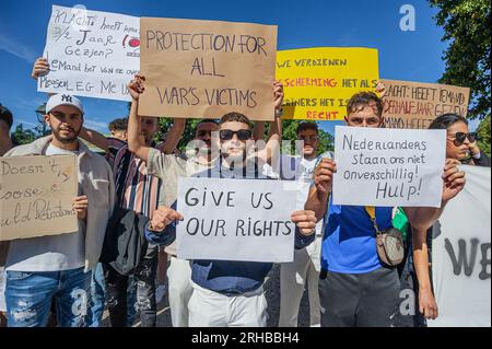 L'Aia, Paesi Bassi. 14 agosto 2023. Gli studenti tengono dei cartelli che esprimono le loro opinioni al Koekamp Park durante la protesta. L'invasione di Putin in Ucraina ha visto non solo l'evacuazione di massa dei suoi indigeni, ma anche l'evacuazione del suo corpo studentesco straniero che studiava in quel paese. Invece di tornare a casa, la maggior parte fuggì nella vicina Europa e più di quattromila entrarono nei Paesi Bassi. All'epoca anche loro avevano ottenuto asilo con diritti simili a quelli concessi ai cittadini ucraini. Gli studenti che avevano presentato domanda di asilo ora considerano questa una forma di intrappolamento; ora se ne sono Foto Stock