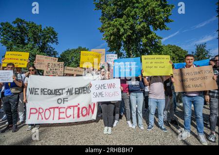 L'Aia, Paesi Bassi. 14 agosto 2023. Gli studenti tengono uno striscione e dei cartelli che esprimono le loro opinioni al Koekamp Park durante la protesta. L'invasione di Putin in Ucraina ha visto non solo l'evacuazione di massa dei suoi indigeni, ma anche l'evacuazione del suo corpo studentesco straniero che studiava in quel paese. Invece di tornare a casa, la maggior parte fuggì nella vicina Europa e più di quattromila entrarono nei Paesi Bassi. All'epoca anche loro avevano ottenuto asilo con diritti simili a quelli concessi ai cittadini ucraini. Gli studenti che avevano presentato la richiesta di asilo ora considerano questa una forma di intrappolamento Foto Stock