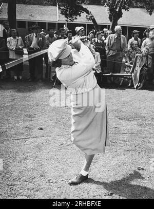 Pebble Beach, California: c. 1951Babe Didrikson dà una dimostrazione di guida di golf apparentemente con una sola gamba. Foto Stock