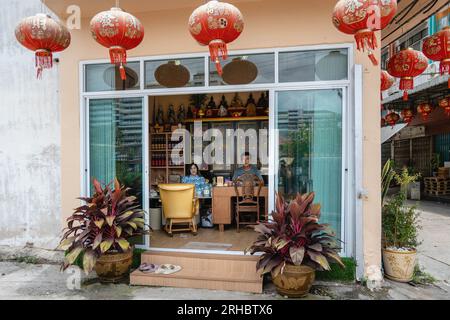 L'ingresso della fabbrica di salsa di soia fatta in casa di Hao Yong Seng con i proprietari Pun-Saharat Kamolsakdavikul, 62 anni, e il boss Nea Rung-Susama Sunsiang, 57 anni. “Hao Yong Seng” è l’unica fabbrica di salsa di soia fatta in casa rimasta a Bangkok, da 3 generazioni, per più di 100 anni, la famiglia non ha mai cambiato la formula e mantiene ancora il processo di produzione tradizionale, che richiede fino a 6 mesi per ottenere una bottiglia, nella comunità di Khlong Bang Luang, che era un distretto economico, questa è l'unica fabbrica di salsa di soia rimasta. Foto Stock