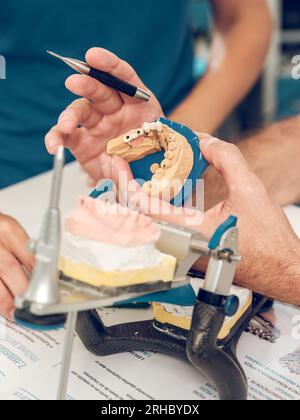 Coltivare un dentista maschile non riconoscibile utilizzando gesso durante la produzione di protesi in laboratorio dentistico Foto Stock