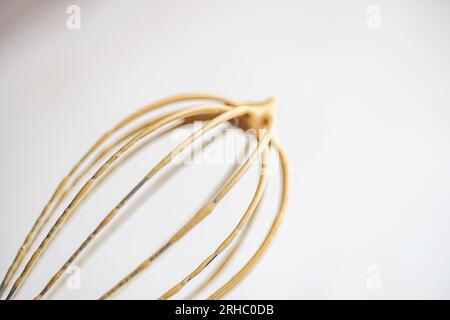 Primo piano di una frusta ricoperta di crema di caffè Foto Stock
