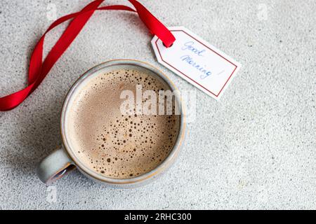 Vista dall'alto di una tazza di caffè lattiginoso o cioccolata calda con un'etichetta Good Morning Foto Stock