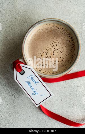 Vista dall'alto di una tazza di caffè lattiginoso o cioccolata calda con un'etichetta Good Morning Foto Stock