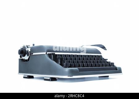 macchina da scrivere meccanica vintage vecchio stile in metallo, con chiavi nere e una leva distinta per il ritorno a carrello. Impostato su uno sfondo bianco, visualizzato un Foto Stock